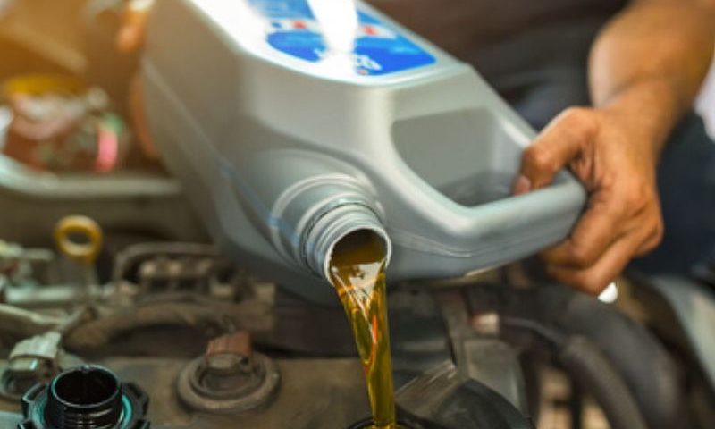 man pouring fresh oil to engine