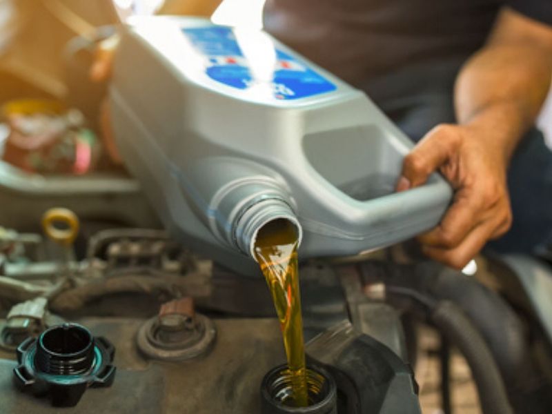 man pouring fresh oil to engine